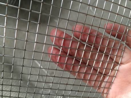 A piece of stainless steel wire mesh in a woman's hand.