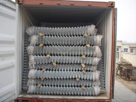 Chain link mesh rolls in container with wooden sticks between two layers.