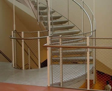 Stainless steel ferrule rope mesh is installed as irregular stair balustrade fill.