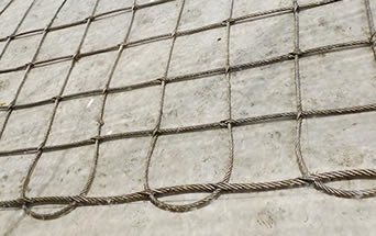 A piece of interwoven type square cable mesh placed on the floor.